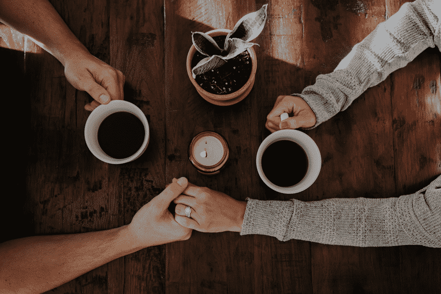 dos manos y dos tazas de café